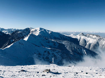 Scenic view of snowcapped mountains against clear blue sky