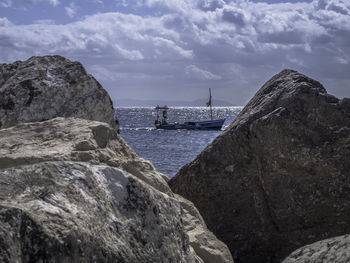 Rock formations by sea against sky