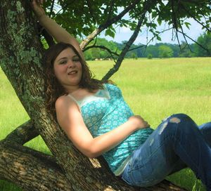 Young woman sitting on tree trunk