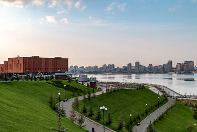 Scenic view of river by buildings against sky