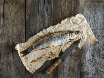 Directly above shot of herring fish on paper at table