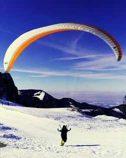 Person paragliding over blue sky