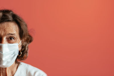 Close-up portrait of a man against red background