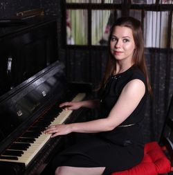 Portrait of smiling woman playing piano at home