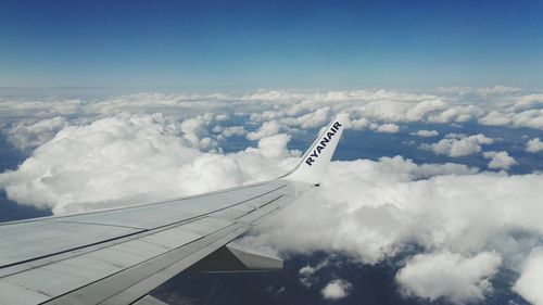 Aerial view of aircraft wing over clouds