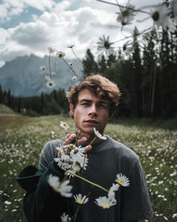 Portrait of young man throwing flower on land