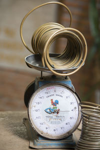 High angle view of coiled metal with old-fashioned weight scale on table