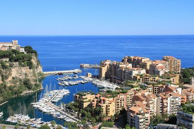 High angle view of buildings by sea against clear sky