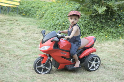 Portrait of cute boy sitting on motorcycle