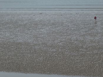 High angle view of people standing on beach