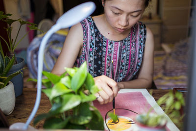 Midsection of woman holding food while sitting on table