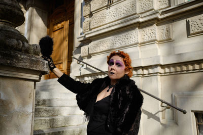 Young woman standing against building