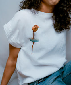 Midsection of woman holding white dress