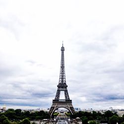 Eiffel tower in city against cloudy sky