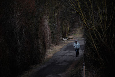 Rear view of man walking in forest