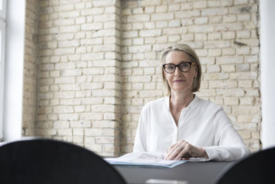 Mature businesswoman working in office, reading documents