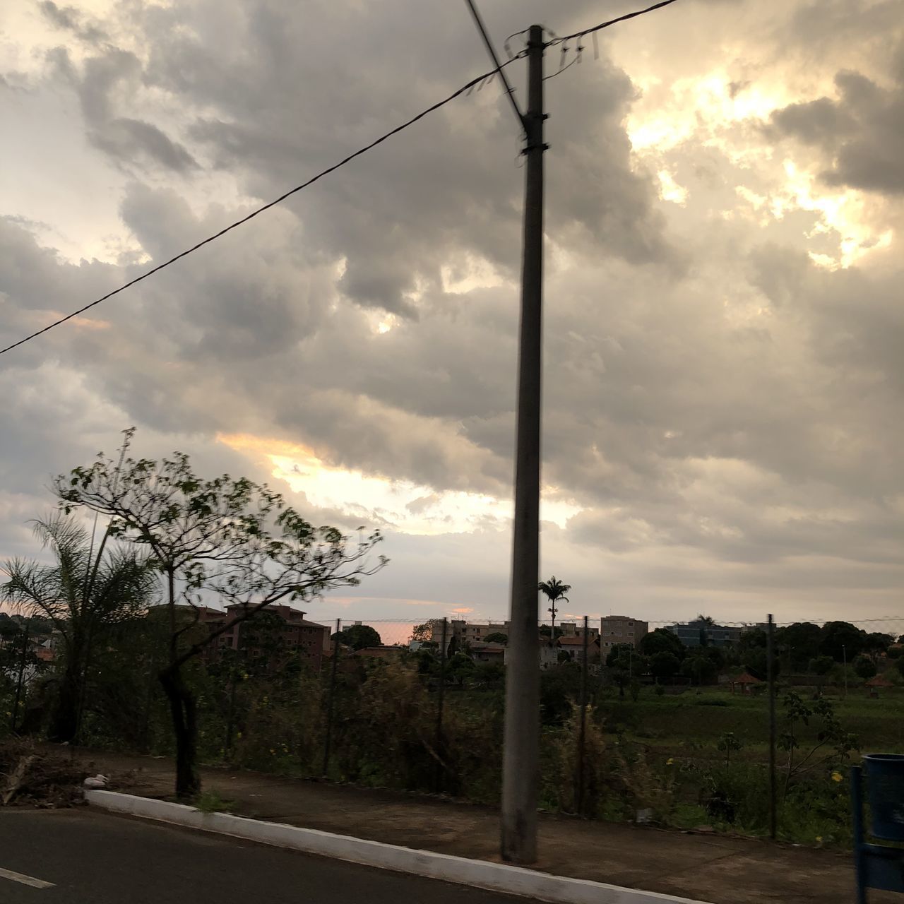 ELECTRICITY PYLON BY ROAD AGAINST SKY