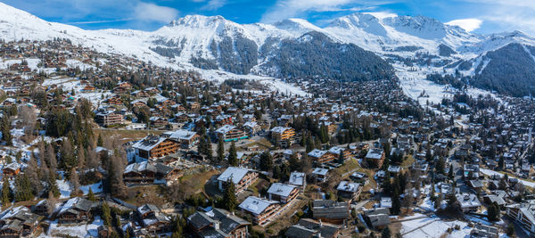 Aerial view of townscape against snowcapped mountains