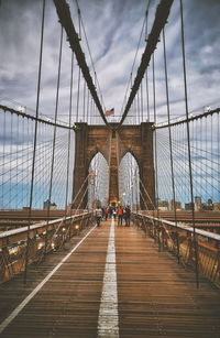 View of suspension bridge against cloudy sky