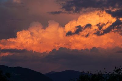 Low angle view of silhouette mountains against dramatic sky