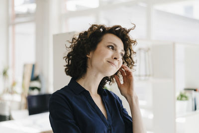 Businesswoman in office thinking and smiling