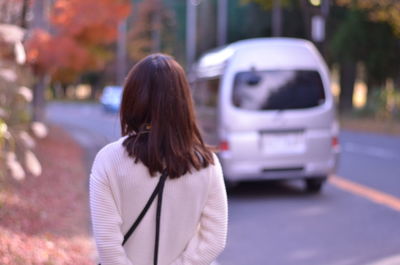 Rear view of woman walking on road