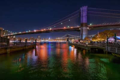 Suspension bridge over river at night