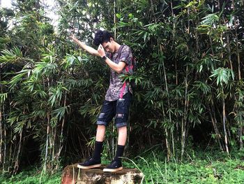 Full length of man standing by tree in forest