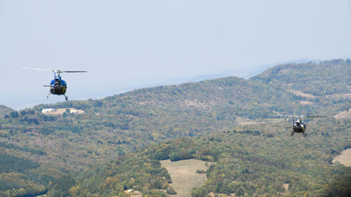 Airplane flying over mountains against clear sky