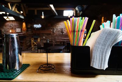 Close-up of straws and paper in container on table