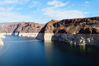 Scenic view of sea and mountains against blue sky