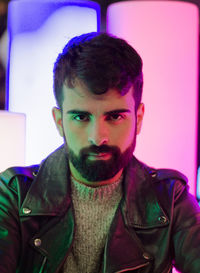 Portrait of bearded young man wearing leather jacket in nightclub