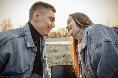 A young man and a woman want to kiss during a break from work on a laptop