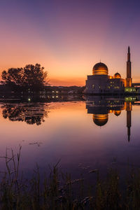 Reflection of buildings in lake at sunset