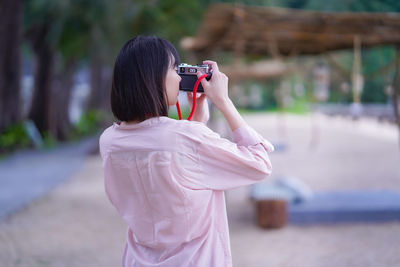 Rear view of woman photographing