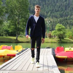 Full length portrait of young man standing against trees