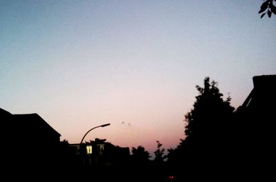 Low angle view of silhouette trees against sky at dusk