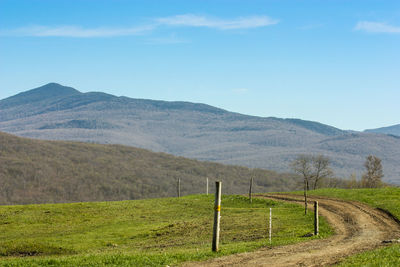 Scenic view of field and mountains against sky