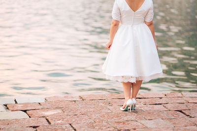 Low section of woman standing on shore