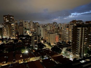 High angle view of illuminated buildings against sky at night