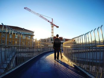 Full length of woman walking in city against clear sky