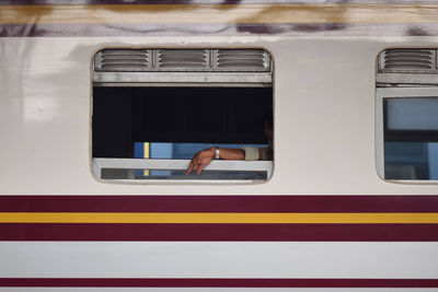 Cropped hand of man seen through train window