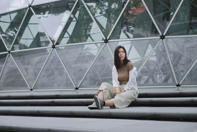 Portrait of young woman sitting on staircase