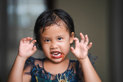 Little girl with scary face expression get ready for halloween party.