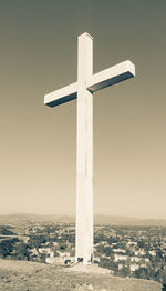 Cross on beach against clear sky