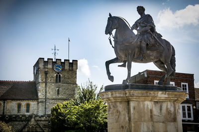 Low angle view of statue against historic building