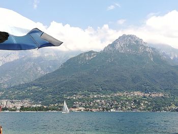 Scenic view of sea by mountains against sky