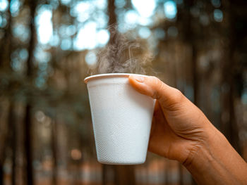 Close-up of hand holding coffee cup