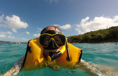 Man swimming in sea against sky