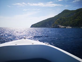 Scenic view of sea by mountains against sky